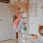 Dziewczynka bawi się przy drabince gimnastycznej