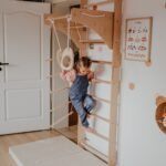 Dziewczynka bawi się przy drabince gimnastycznej