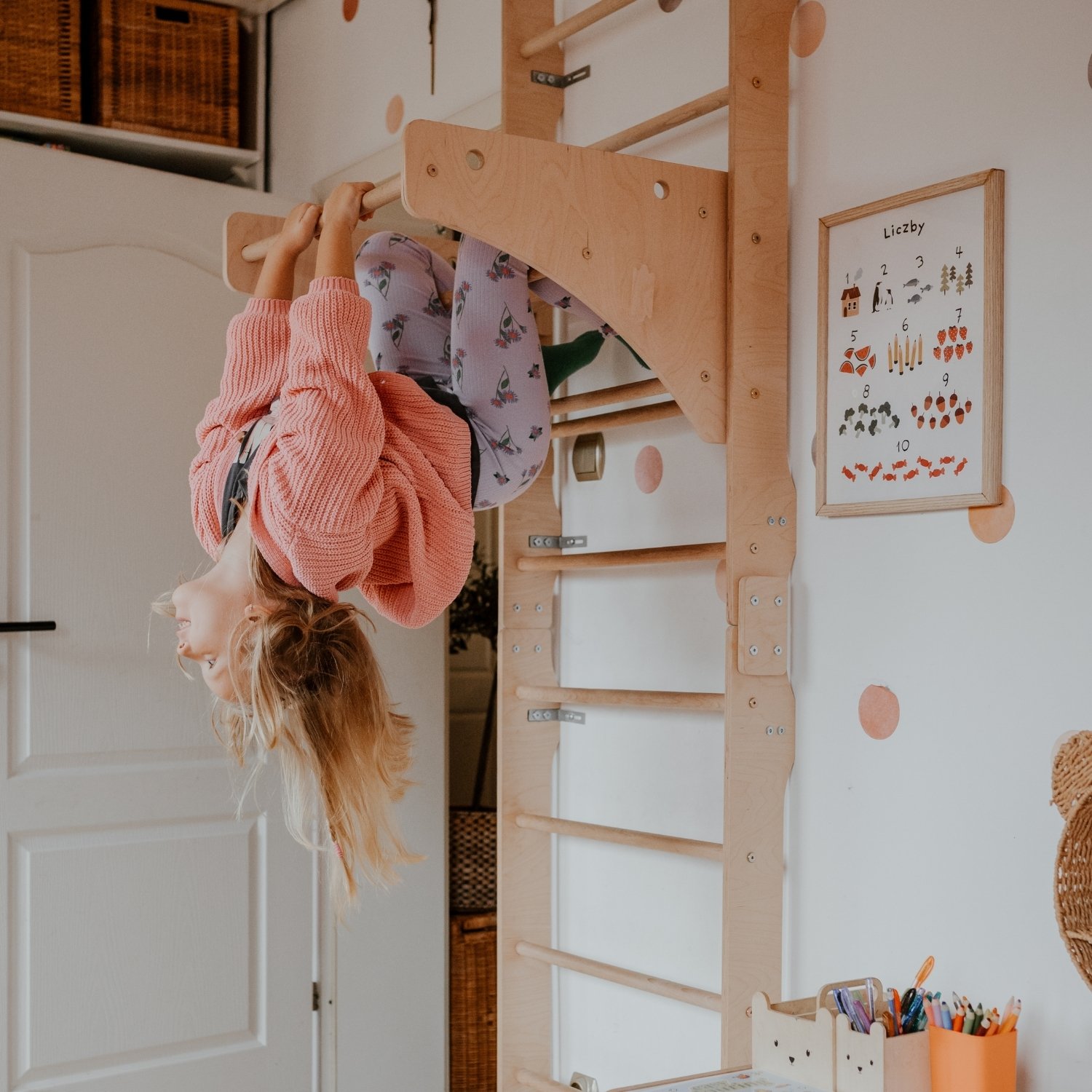 Dziewczynka bawi się przy drabince gimnastycznej