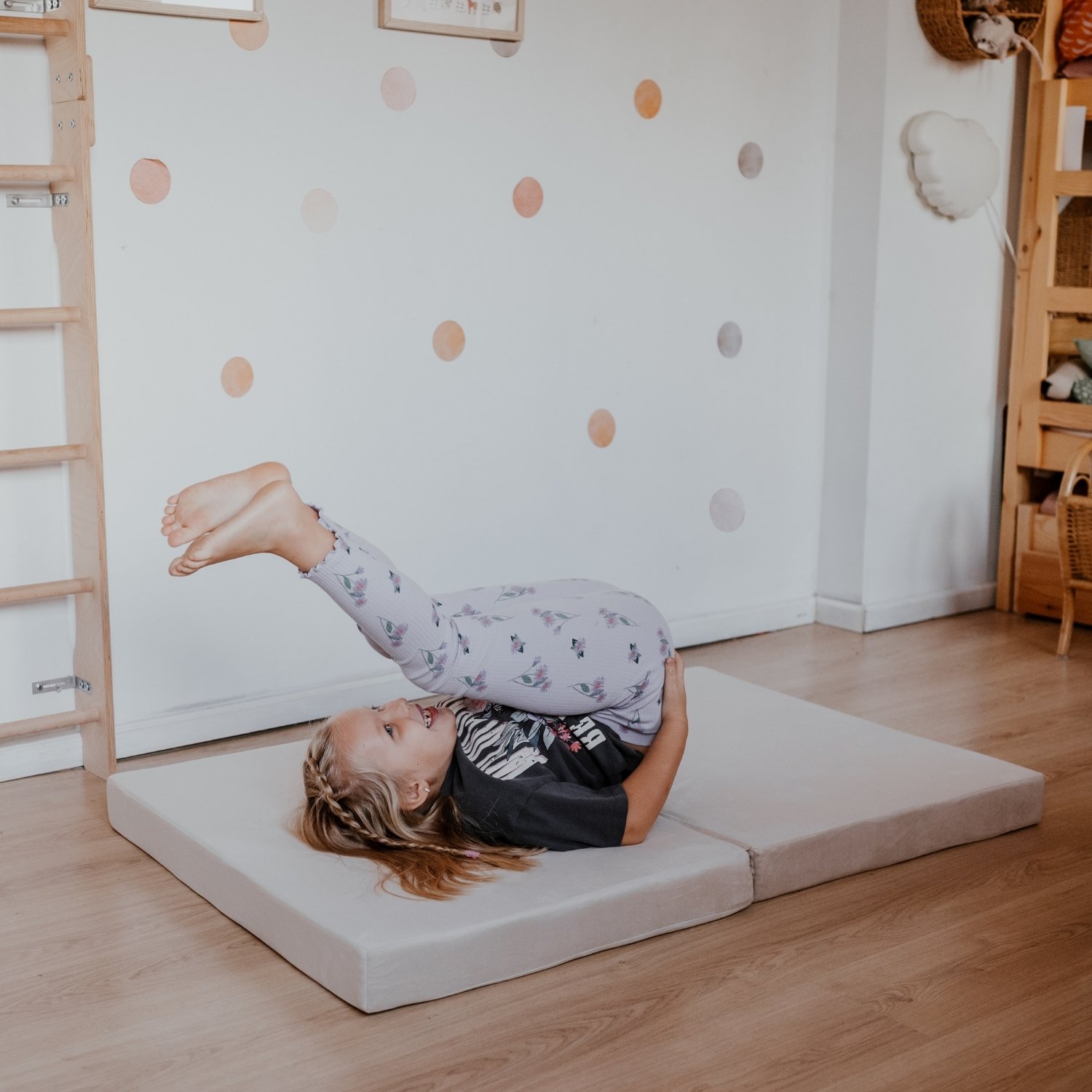 Dziewczynka ćwiczy na materacu beżowym